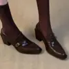 Nuevos mocasines negros texturizados de tacón grueso para mujer, con un diseño retro estilo británico, un detalle de hebilla y una parte superior de piel suave, creando un look chic y elegante.