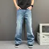 Calça jeans flare retro azul com costura dividida para homens, adequada para uso diário e para ir ao trabalho, com um design solto, de perna reta, ligeiramente larga e fluida, uma calça moderna