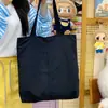 Un bolso tote fresco y relajado, ligero, con un diseño de inspiración coreana, casual y minimalista, perfecto para que los estudiantes lo usen durante sus vacaciones o para ir de compras.. También se puede llevar como bolso de hombro