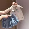 Conjunto de duas peças de verão para meninas, estiloso e moderno para crianças, apresentando um colete xadrez floral com gola de boneca e shorts em formato de botão.