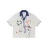 Nanxia Disfarce Verão Desenho Animado Gravata Grafite Manga Curta Camisa Polo Solta Tendência Marca Estilo Unissex Casal Meia-Manga Top