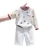 Suéter de punto de estilo coreano para niños, nuevo de otoño 2026, con estampado de dibujos animados, letras, bloques de color, y pantalones casuales blancos para niños