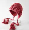 Gorro de Punto con Borla y Correa de Flor Grande Tejida en Crochet Moda Femenina Tendencia Otoño e Invierno Protección Cálida para los Oídos Gorro de Lana
