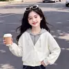 Conjunto moderno de dos piezas para niñas 2026: top con capucha de moda con diseño de dos piezas falso, combinado con pantalones vaqueros estilo coreano