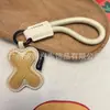 Venta al por mayor transfronteriza de llaveros japoneses y coreanos con letras en inglés, dijes para bolso de cuero dopamina, pequeños accesorios y regalos
