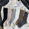 Calcetines de felpa con etiqueta en el talón para niños, primavera y otoño, viento frío, nicho, ins, moda, color liso, versátil, negro, tubo largo, calcetines de moda