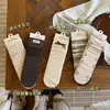 Songmu" Serie de Color Maillard de Almendra y Avellana Etiqueta de Tela con Lazo Floral Pequeño Retro Calcetines hasta la Media Pantorrilla Calcetines Holgados para Mujer