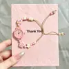 Nuevo y exquisito reloj pulsera con cuentas de corazón, reloj de pulsera con colgante tejido estilo girly, reloj versátil para exámenes, al por mayor