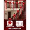 Un juego completo de artículos decorativos para una boda en una casa rural de construcción propia para los novios, incluyendo barandillas de escaleras, letreros festivos y decoraciones colgantes.