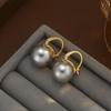 Fiebre de estilo ins mismo estilo estilo Hong Kong retro chic de alta gama aretes de botón de perla de imitación de concha aretes de aguja de plata de alta calidad
