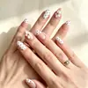 Uñas postizas de venta cruzada más vendidas con flores blancas en relieve, pequeños lunares rojos y un estilo de manicura francesa, con delicados patrones florales y una estética suave.