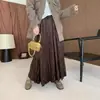 Nova coleção outono/inverno: saia evasê de veludo fluida com barra godê, apresentando bordados estilosos e detalhes em patchwork, e um design versátil de cor sólida