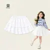 Saia branca plissada estilo coreano 2026 para meninas, com barra franzida, saia curta versátil em linha A, roupas de verão para crianças