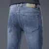 Jeans de alta gama para hombre para primavera y verano, corte recto, ajuste slim, elásticos, pantalones largos de moda de Guangzhou Xintang, estilo versátil de verano