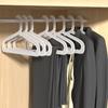 Percha de plástico antideslizante para el hogar, sencilla, para colgar pantalones, para secar ropa en blanco y negro, sin costuras, ahorra espacio, con arco de almacenamiento audaz.