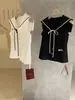 Wgwe8405 Guangzhou Treze Linhas Camisa Feminina Nova Primavera/Verão com Gola Azul Marinho Sem Mangas com Laço Top Elegante