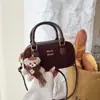 Bolso de mano de alta gama estilo miu 2026 bolso nuevo bolso con charm de oso moda para mujer bolso versátil de un solo hombro cruzado