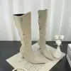 Botas western de bico fino e salto alto até o joelho, outono e inverno de 2026, com saltos agulha de camurça estilo retrô e fivelas de metal