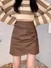 Nueva falda corta de cuero PU plisada de cintura alta estilo 'hot girl' vintage para mujer, adelgazante para otoño e invierno, que cubre la cadera, ajustada al cuerpo
