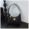 Bolso Pequeño con Accesorio de Mariposa Simple Transfronterizo para Mujer Estilo Nuevo PU Color Sólido Versátil Bolso de Hombro Ligero Bolso de Axila Venta al por Mayor