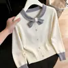 Fotos reales de la colección otoño/invierno 2026: un suéter dulce y de aspecto delicado de manga larga con un pequeño cuello de lazo y ribete de piel de mapache, diseñado para mujeres