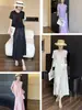 Conjunto de Ropa para Mujer: Un Conjunto de Dos Piezas Adelgazante y Elegante con una Camiseta de Manga Corta de Retazos y una Falda de Moda, un Popular Conjunto Estilo Miyake