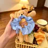 O scrunchie infantil fofo de urso com estampa xadrez azul é extremamente estiloso para prender o cabelo em um coque, proporcionando um visual sofisticado.