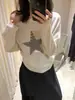Dela, uma coleção de outono doce apresentando um suéter de malha feminino estilo retro americano com padrões de estrelas, enfeites de rebites e um design de ombro assimétrico, mangas compridas e um preço de 67000