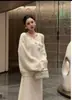 Conjunto de duas peças em tricô floral tridimensional, macio e delicado, estilo francês, com saia afunilada, na cor off-white com pedrarias