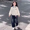 Estiloso top de retalhos com expressão de desenho animado para primavera e outono com pingente de gato fofo, combinado com calça jeans moderna - um conjunto de duas peças