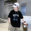 Verão 2026 Novo Estilo Camiseta Infantil Tendência Americana Cool Estampa de Letras Manga Curta Masculina Casual Gola Redonda Confortável para Crianças de Tamanho Médio e Grande