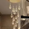 Lámpara de araña de cristal de lujo para un dúplex de villa con una sala de estar de techos altos, que irradia un ambiente sofisticado y de alta gama, y que cuenta con un gran accesorio de iluminación de escalera giratoria