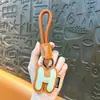 Llaveros de 26 letras inglesas transfronterizos, colgantes para bolsos de cuero, llaveros para mochilas escolares y de coche, accesorios para cordones, venta al por mayor de comercio exterior