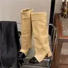 Sin embargo, las nuevas y elegantes botas hasta la rodilla cuentan con un tacón alto, punta redonda inspirada en Chanel, tacón grueso y un elegante diseño de bloques de color.