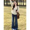 Usa un atuendo completo de otoño e invierno que irradie una vibra madura y elegante, que consista en un cárdigan, un top de punto tipo camisola y jeans