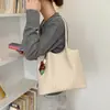 Bolso de hombro tejido coreano nuevo 2026 para el uso diario, tote exquisito, bolso de mano de moda para mujer con colgante de patrón de otoño