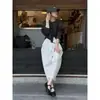 Deslumbrante roupa de outono: um conjunto de uma camisa preta de manga longa curta e calças brancas largas cropped, conjunto de duas peças