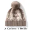 Nova coleção outono e inverno: gorro de tricô simples e versátil com pompom, feito de cashmere, apresentando um design color-block com um pequeno motivo de veado, oferecendo um visual moderno, casual e quente