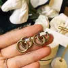 Precio de fábrica al por mayor comercio exterior joyería de cobre elegante retro hacer viejo pendientes Doble G simples estilo INS atmosféricos pendientes de botón con letra para mujer