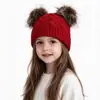 Suministro exclusivo transfronterizo de gorro de punto trenzado para niños nuevo de otoño e invierno con lindos pompones dobles, cálido, a prueba de viento y protector de orejas