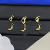 Pendientes de botón con letras y logo de marca de lujo europea y americana transfronteriza, versión de alta gama nueva, pendientes de trébol de cuatro hojas con aguja de plata para mujer, venta al por mayor