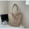 Bolsa de mano tipo tote simple de estilo coreano al por mayor para mujer 2025 Verano Nuevo Gran Capacidad Hombro Único Lona Versátil Bolso de Axila