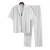 Conjunto masculino branco de manga curta, corte slim, com listras verticais texturizadas, incluindo uma camisa cardigã e calça comprida com cordão, um conjunto de duas peças de uma fábrica de exportação