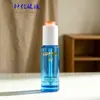 Botella de vidrio redonda recta escalonada azul transparente de 30 ml para aceites esenciales en stock, botella dispensadora cosmética con gotero de presión transparente para sérum