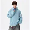 Sudadera con capucha de punto gofre estilo americano con tres rayas y bloques de color, creando un look relajado y casual, perfecta para otoño y como atuendo de pareja.