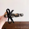 Presilha de cabelo tipo laço com strass preto, resistente, leve e luxuosa, com acabamento texturizado, perfeita para estilizar e prender fios soltos na testa, adicionando um toque elegante.