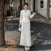 Colección nueva de alta calidad: un conjunto de vestido de dos piezas que presenta un top bordado de encaje calado y una falda, en un color blanco roto liso