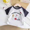 2026 Nova Camiseta Infantil de Manga Curta com Estampa de Desenho Animado, Color Block e Detalhe de Renda, Top Estiloso e Versátil
