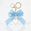 Fornecedor e Vendedor de Chaveiros de Pulseira Grandes com Laço de Pérola Artificial, Tags Coloridas de Liga Metálica com Fita e Pingentes para Bolsas