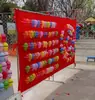 Praça do shopping barraca de rua estande de tiro de balões enchendo balões pistola do dono da barraca parque feira noturna tecido de alvo equipamento jogo